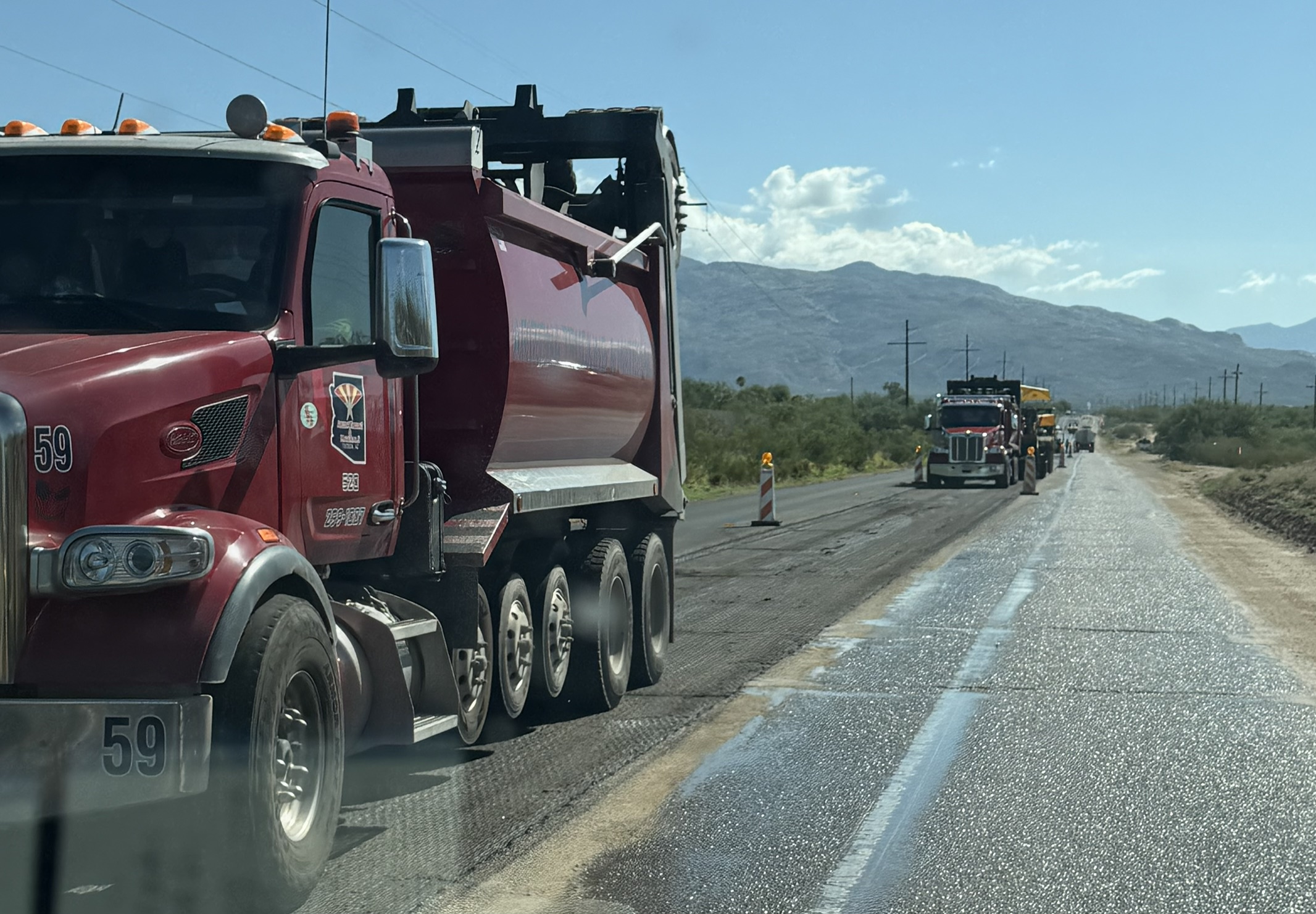 Large truck pour asphalt on a roadway to repave it.
