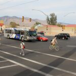Tucson intersection with vehicles, a bicycle rider, and a pedestrian.