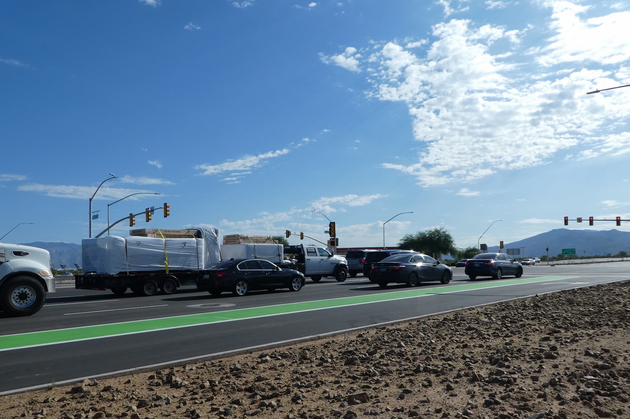 Cars line up at a newly paved intersection.